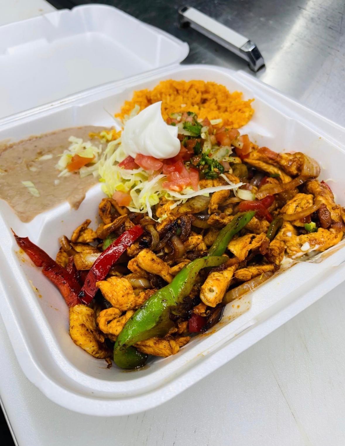 Chicken fajita plate with peppers, onions, rice, beans, and fresh pico de gallo